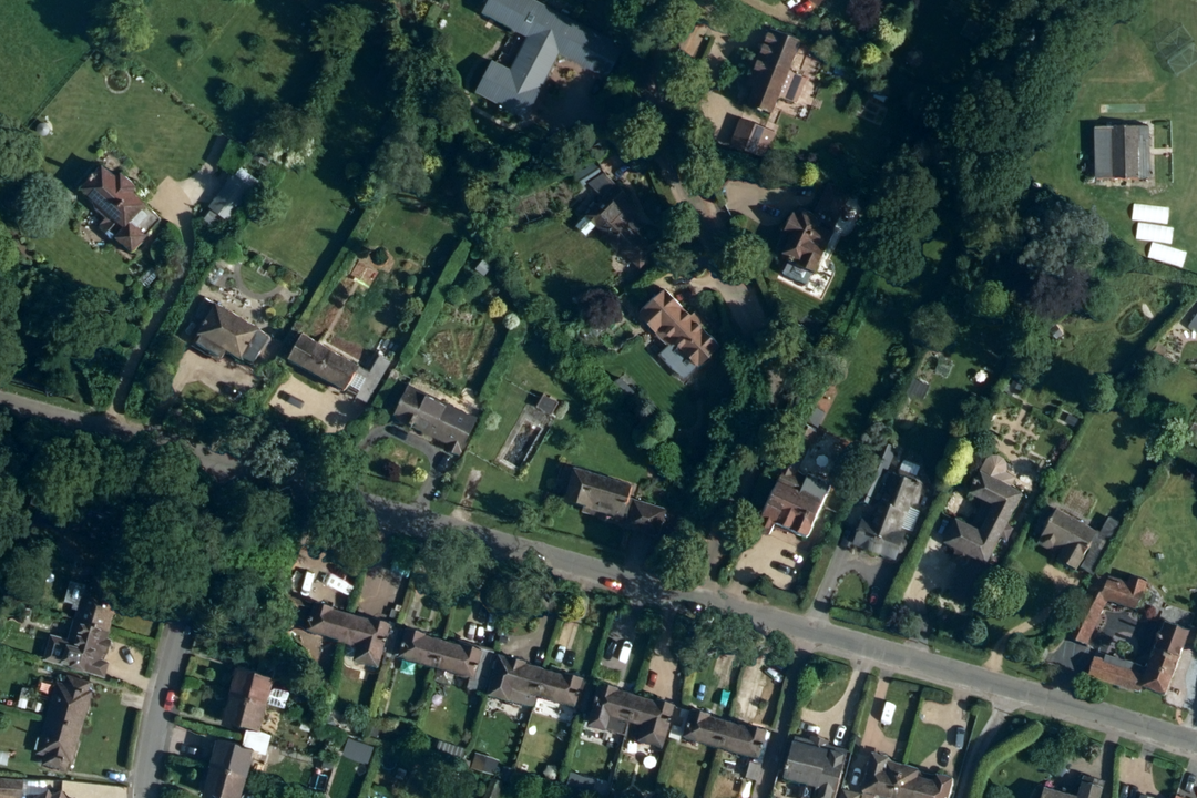 OS aerial imagery section of a suburban area with detached houses set in large gardens with mature tree canopy along a main road
