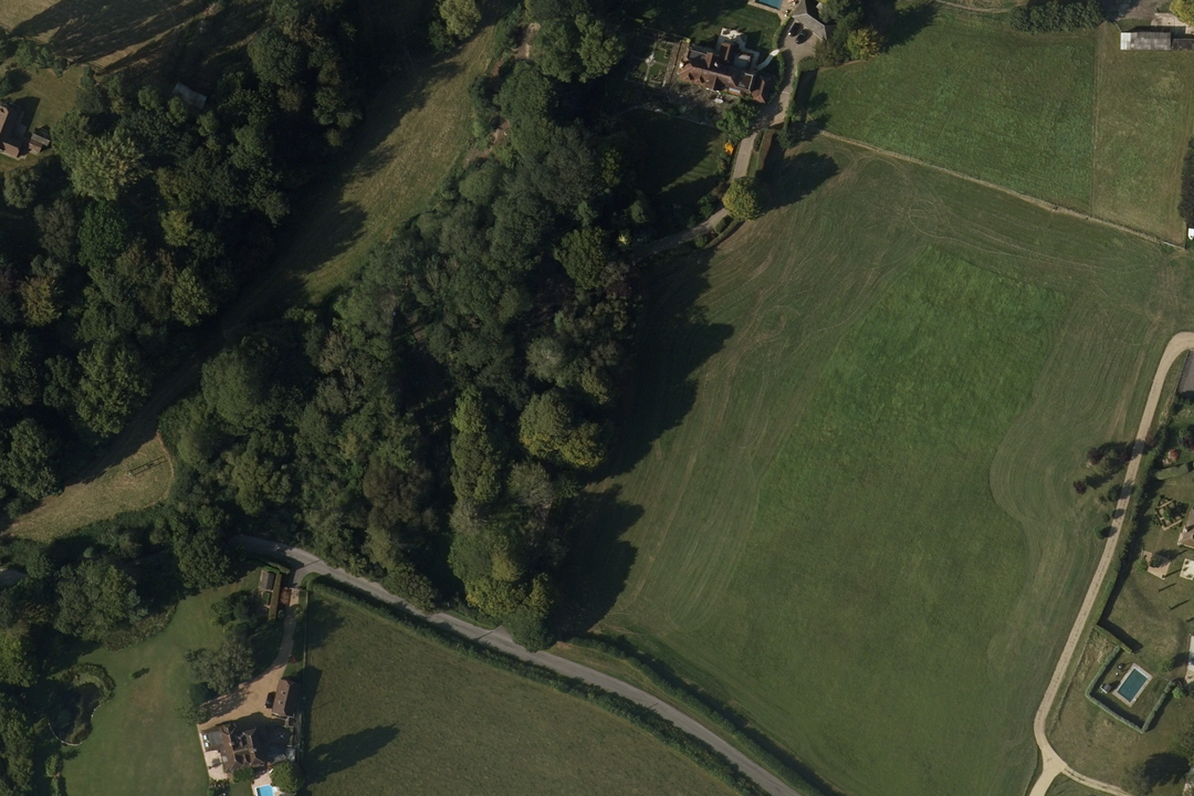 OS aerial imagery section of open fields and mature tree belts surrounding a rural property with paddocks and formal grounds