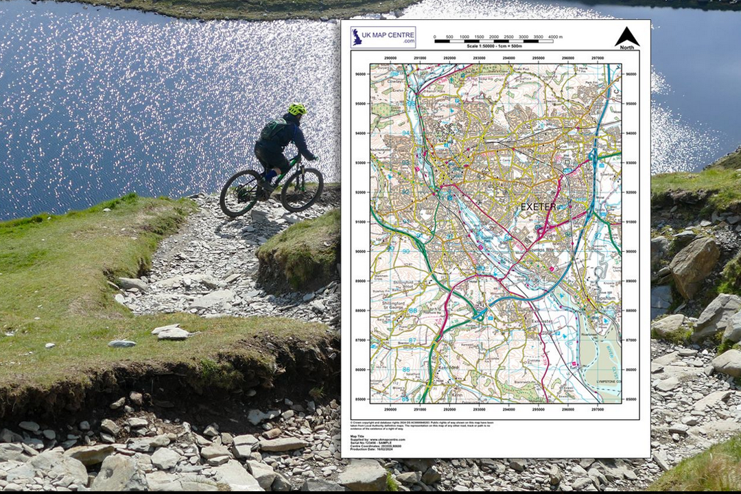 Mountain biker descending a rocky trail beside a loch with an OS 1:50 000 Landranger extract overlaid showing road network and settlements